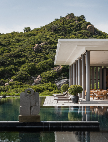 Ben Richards photograph of a modern pavilion extending over water towards forested hillside at Amanoi.