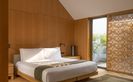 Principal bedroom at Amanyangyun with warm wooden walls and contemporary furnishings.
