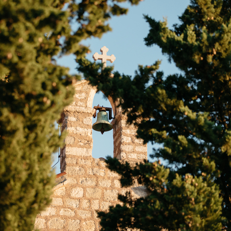 Stone tower framed by pine trees at Aman Sveti Stefan, Montenegro.