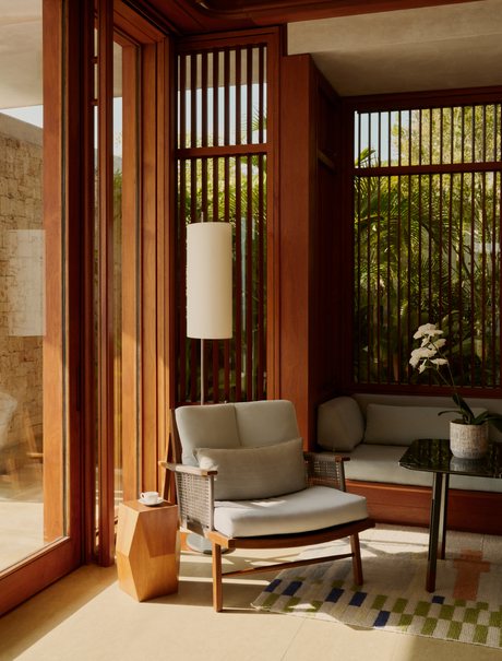Sala de estar de la casa de dos dormitorios en el resort Amanera, con puertas de madera y mobiliario contemporáneo.