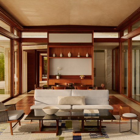 Two-bedroom Casa living room at Amanera, with wooden beams, fireplace and modern seating.