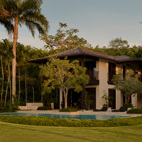 Amanera villa with modern architecture surrounded by lush tropical gardens and palm trees.