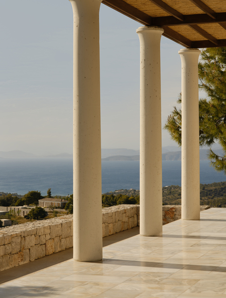 Villa terrace with stone columns overlooking the Aegean Sea at Amanzoe resort.