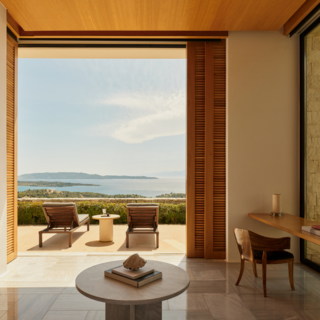 Villa suite with terrace overlooking coastal landscape at Amanzoe resort, Greece.