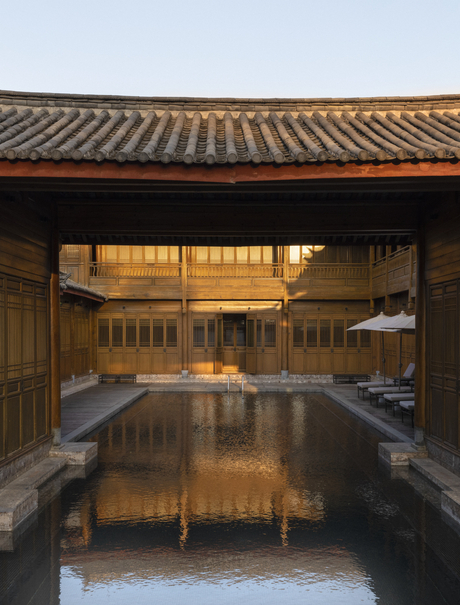 Amandayan courtyard at dusk, reflecting golden light on still water beneath a traditional tiled roof.