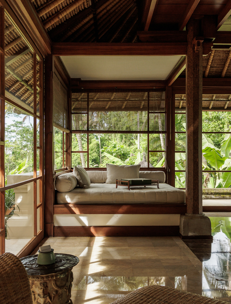 Duplex suite at Amandari with four-poster bed, wooden frame, and garden views through open doors.