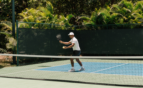 Guest playing pickleball on outdoor court at Amanera, Dominican Republic.