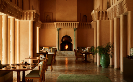 Amanjena restaurant Nama with warm-lit archway, dining tables, and Moroccan architectural details.