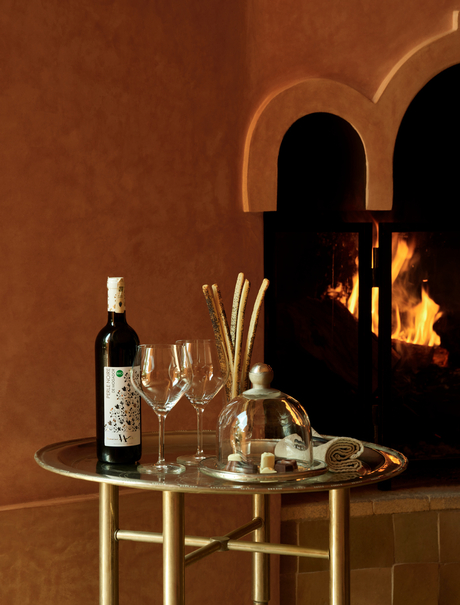 Welcome drinks displayed on a table at Amanjena, Morocco, featuring wine, glasses, and fresh flowers.