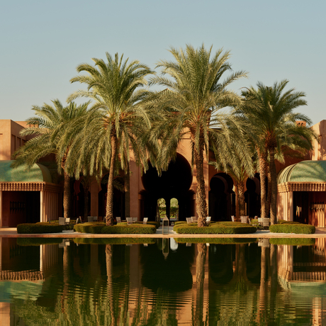 Central courtyard with reflecting pool and date palms at Amanjena, Morocco.