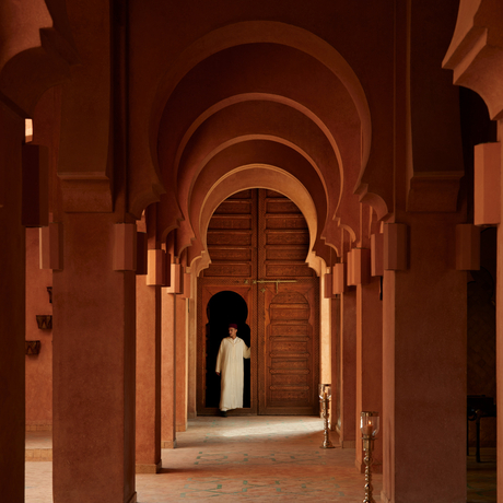 Entrance lobby at Amanjena with terracotta arches and wooden doors, Morocco.