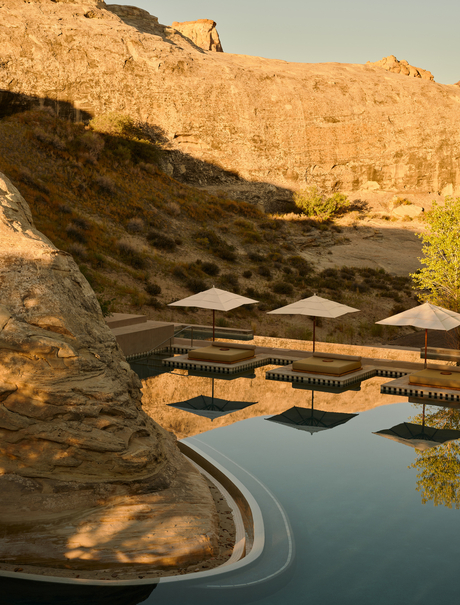 Main pool at Amangiri reflecting terracotta cliffs at sunrise in the Utah desert.