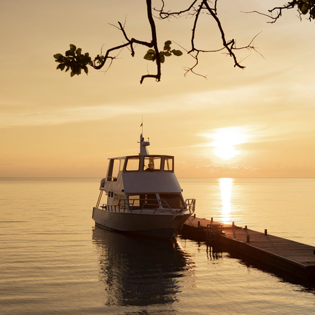 Wooden boat moored at Amanwana at sunset, Sumbawa, Indonesia.