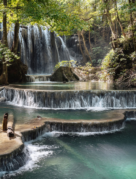Mata Jitu waterfall cascades into a turquoise plunge pool surrounded by lush forest at Amanwana, Sumbawa, Indonesia.