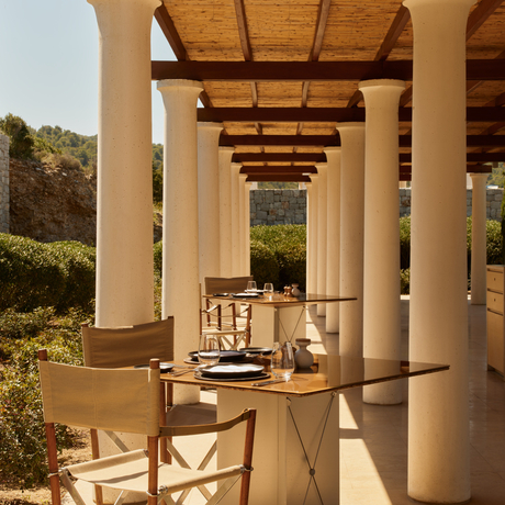 Restaurant de la plage d'Amanzoe, avec colonnes blanches et vue sur la mer Égée.