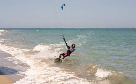Kitesurfer riding waves in turquoise Caribbean waters at Amanera, Dominican Republic.