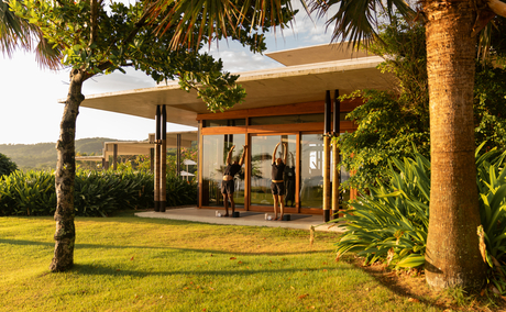 Amanera resort spa pavilion with cream canvas canopy, surrounded by lush tropical gardens and palm trees at dusk.