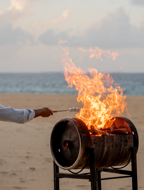 Beachfront fire pit at Amanera resort, Dominican Republic, with flames glowing against the evening sky.