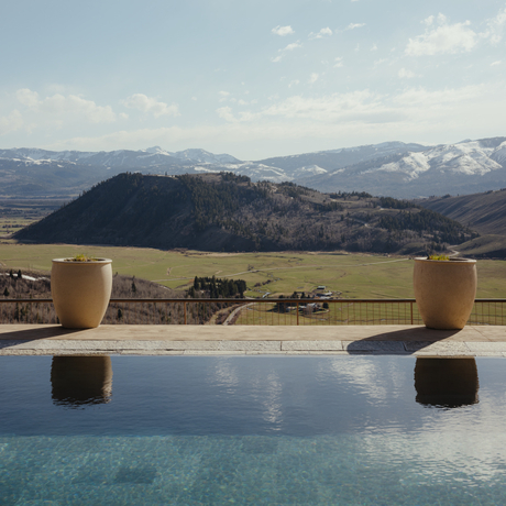 Infinity pool at Amangani overlooking the Wyoming landscape, with snow-capped mountains in the distance.