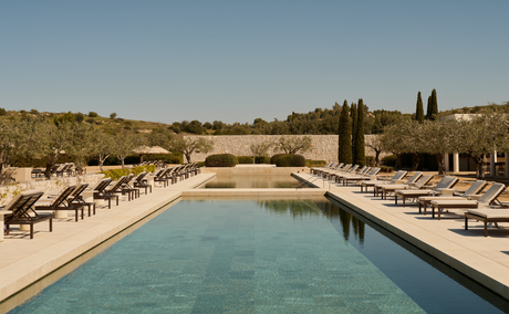 Vue sur la piscine et les jardins terrasses d'Amanzoe, resort en Grèce.