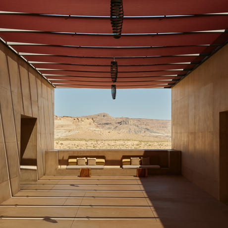 Wooden deck at Amangiri with view towards desert landscape and seating area beyond.