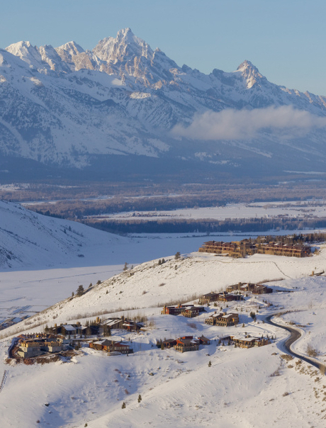 Snow-covered landscape surrounding Amangani in winter, with distant mountain peaks and valley below.