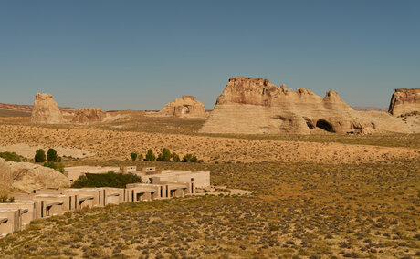 Amangiri's terracotta-coloured buildings nestled against a dramatic desert landscape under clear skies.