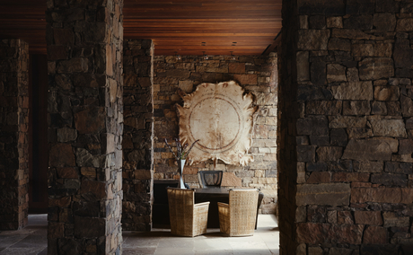 Amangani lobby entrance with stone archway and wooden ceiling details.