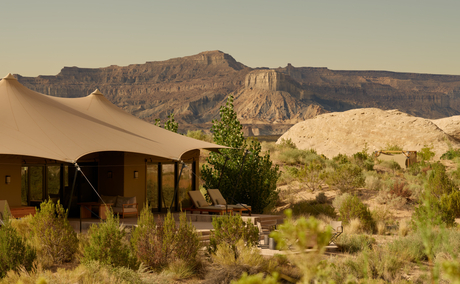 Amangiri's tented pavilion exterior with red rock formations rising behind the Utah desert landscape.