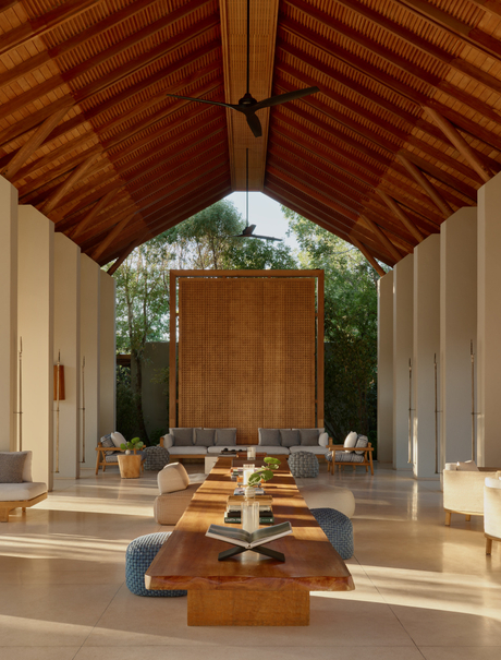 Amanyara's arrival pavilion with wooden ceiling, central wooden doors, and seating area framed by columns.