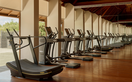 Row of treadmills in Amanyara's resort gym with wooden beams and ocean views.