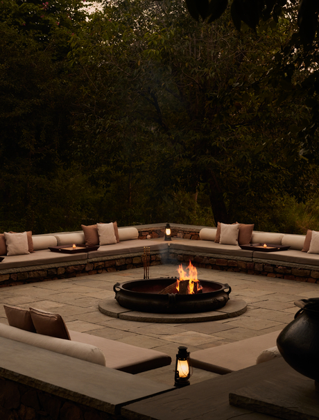 Curved seating arrangement around a central fire pit at Aman-i-Khas, India, at dusk.