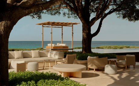 Amanyara's main pool terrace with wooden pergola, lounge seating and turquoise Caribbean Sea beyond.