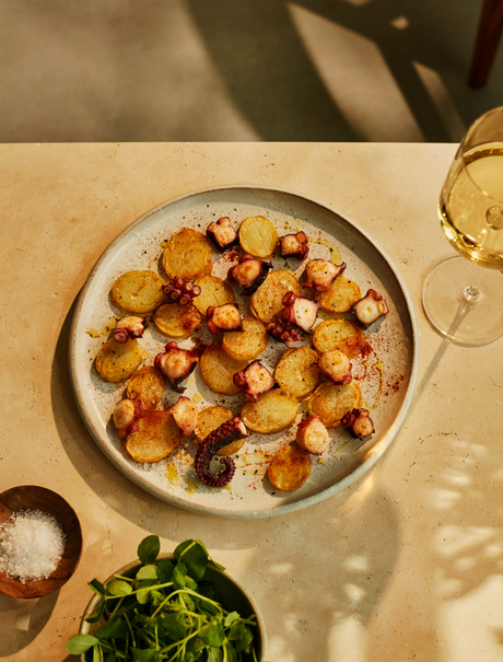 アマンプリのリゾートで提供される、焼いた根菜と新鮮なハーブを盛り付けた料理。