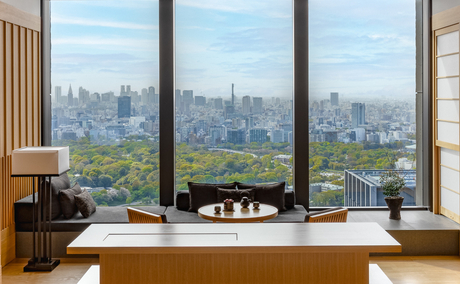 Spacious room at Aman Tokyo with expansive windows overlooking the Tokyo skyline and city below.