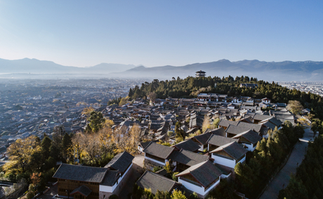 Aerial view of Amandayan hotel nestled in the Chinese hills overlooking a sprawling valley below.