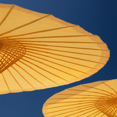 アマンプリのリゾートで、深い青空を背景に黄色いビーチパラソルが2つ並んでいる。