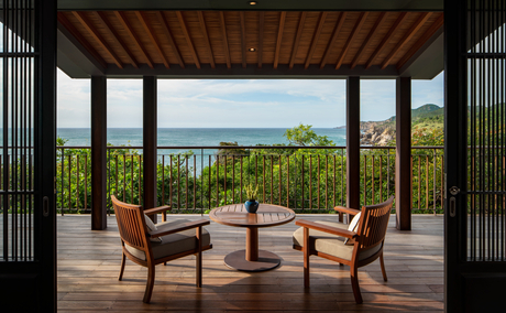 Two wooden chairs on a terrace at Amanoi, overlooking coastal landscape and ocean vista.