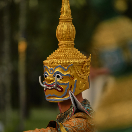 Close-up of a gilded Lao masked dance drama figure at Amantaka's poolside dinner performance.
