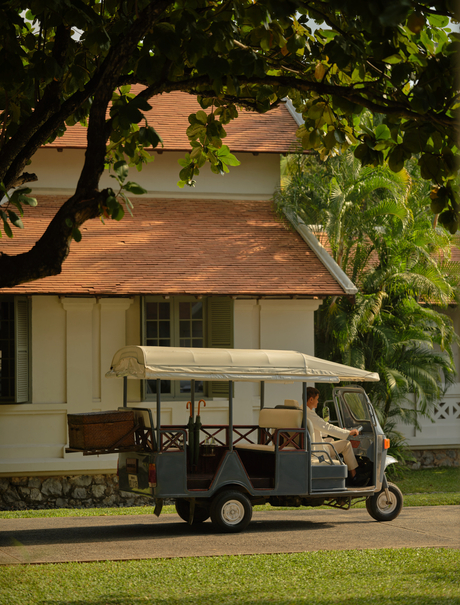 Tuk-tuk parked beneath trees at Amantaka, Laos resort.