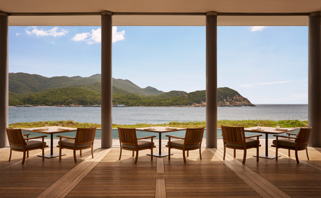 Beach Club Restaurant at Amanoi with dining tables overlooking Vietnam's coastline and mountains.