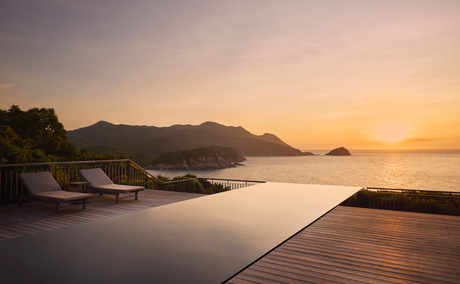 Ocean pool villa at Amanoi overlooking the Vietnamese coast at sunset.
