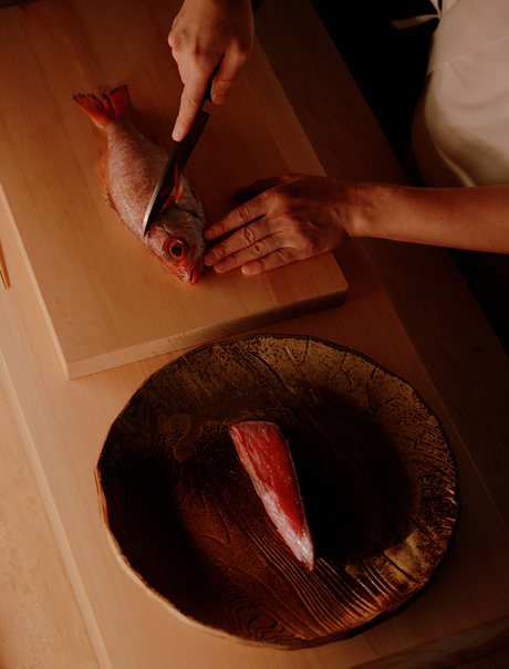 Overhead view of a guest's hands arranging a woven basket at Aman Nai Lert Bangkok.