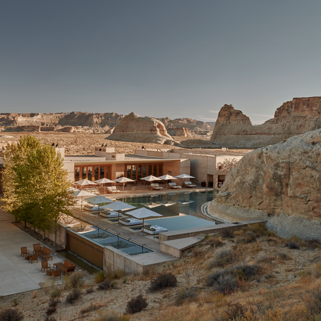 Amangiri's exterior nestled among desert rock formations with a swimming pool and modern architecture at sunset.