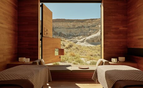 Couples massage room at Amangiri with views over desert landscape through large window.