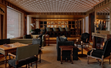 Aman Le Mélézin's salon with billiard tables, seating areas and warm wood finishes.