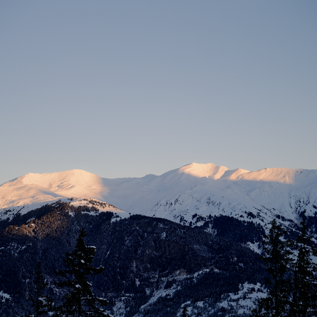 Snow-capped Alpine peaks at Aman Le Mélézin at sunrise, French Alps.