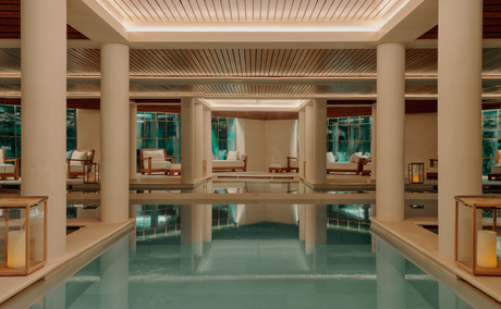 Spa and wellness pool at Aman Le Mélézin, France, with columned architecture and turquoise water.