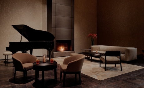 Il Salotto con pianoforte a coda e sedute in pelle presso Aman Rosa Alpina.