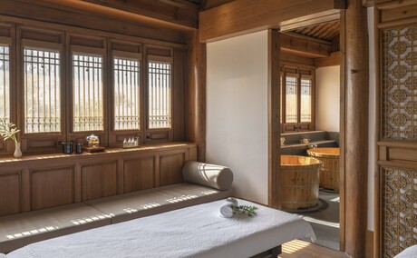 Spa treatment room at Amandayan with wooden lattice windows, soaking tub and calm interior.